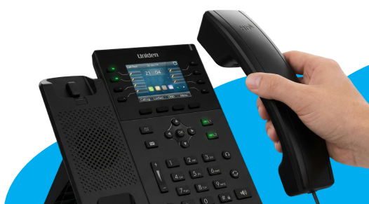 Hand placing down a Uniden desk phone